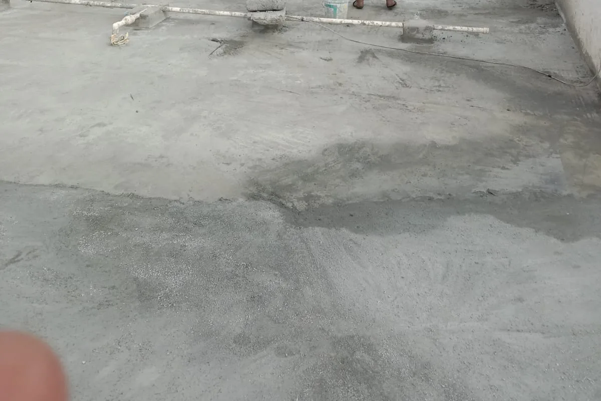 Ultra Max workers preparing a terrace surface along a white parapet wall